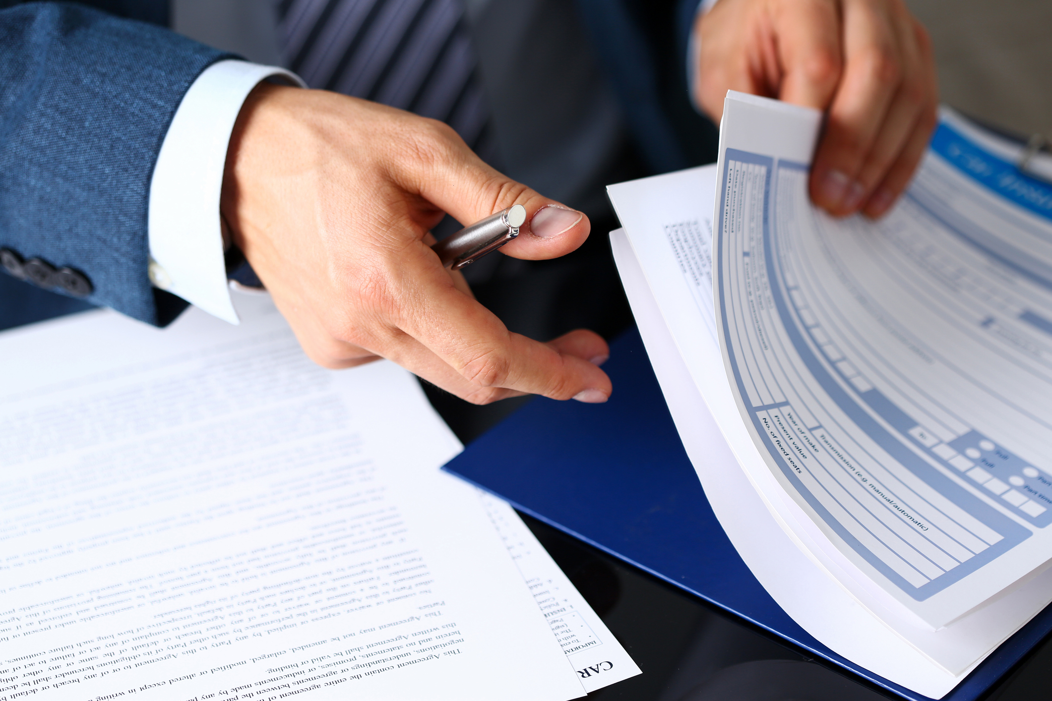 Male arm in suit offer insurance form clipped to pad PMI/PMP